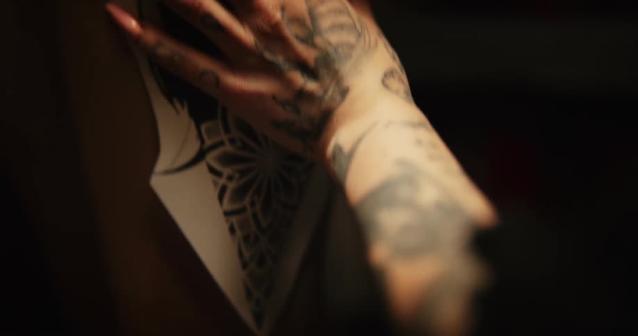 A tattoo artist puts an image on a persons arm
