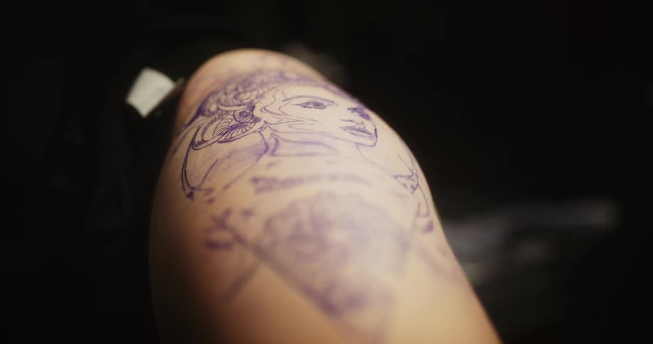 Close up of the outline of a tattoo on the leg of a customer