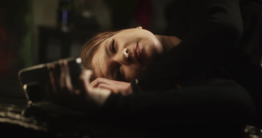 Young woman resting on a couch leisurely browsing her smartphone