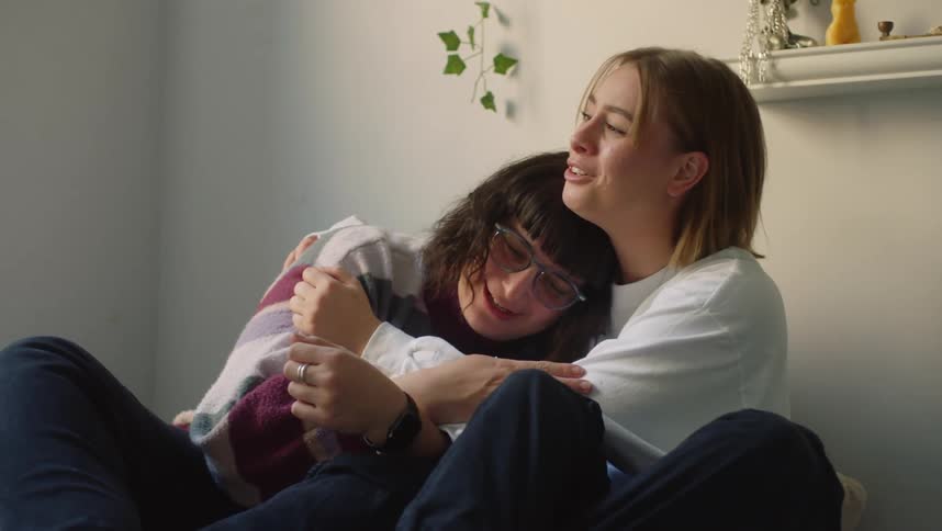 Young couple comfortably sitting on the bed cuddle comfortingly