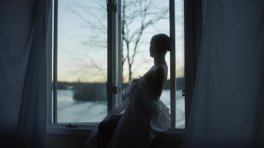 A woman is looking out the window