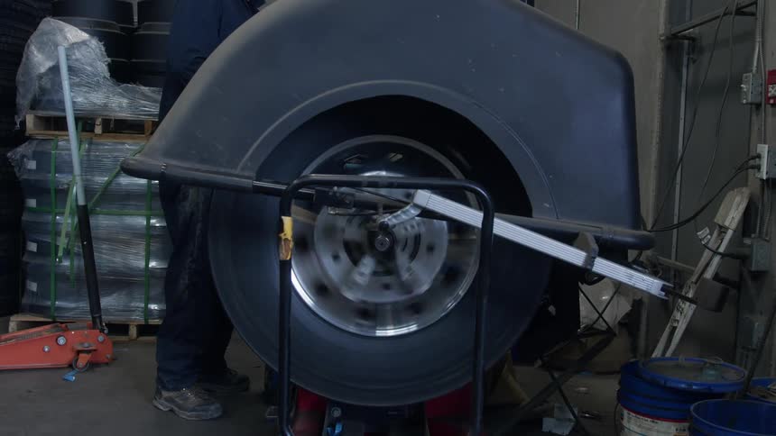 Man closes top on machine rotating tire and waits