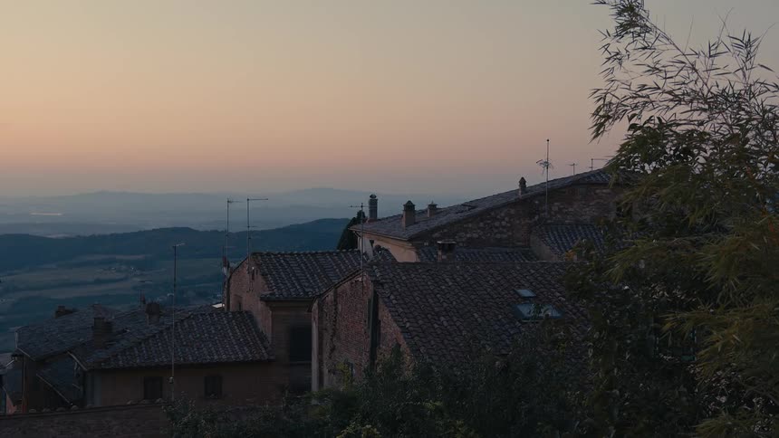Apartment buildings overlook valley stretching to foggy red tinted horizon