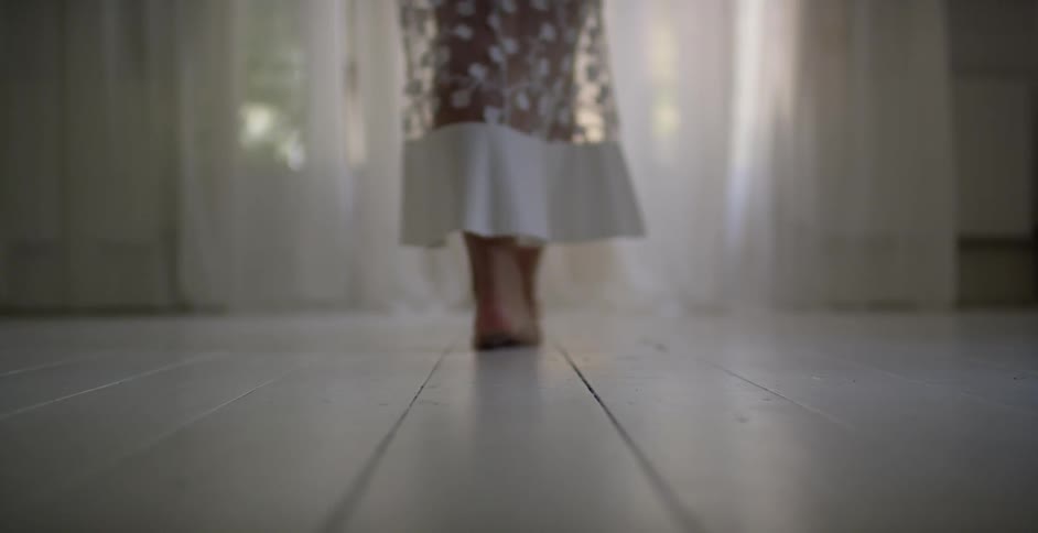 A woman's bare feet walk across a floor