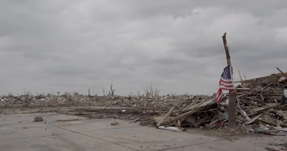 An american flag hanging near storm debris