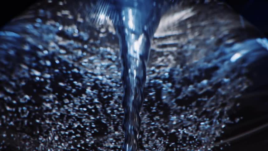 Light shines on bubbles as they swirl around water tornado vortex as it forms twisting and spinning