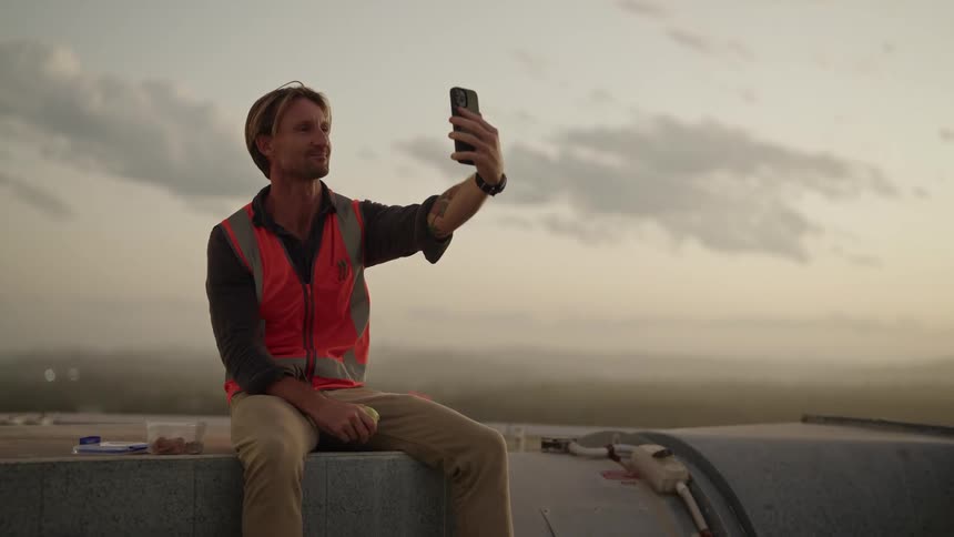 A construction worker talking on a phone