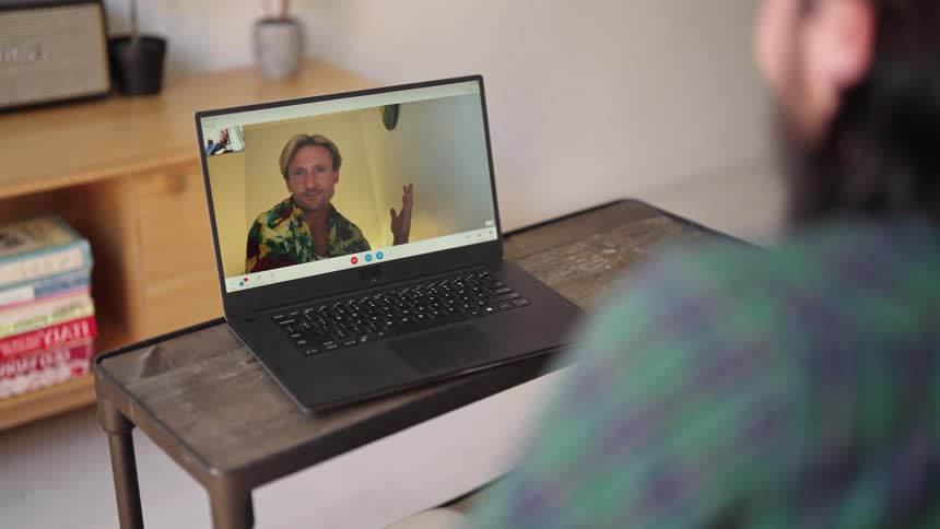 Two men talking to each other on a laptop