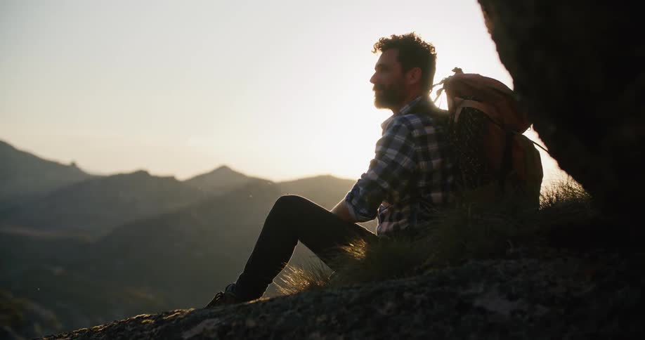 A man is sitting down on the mountain