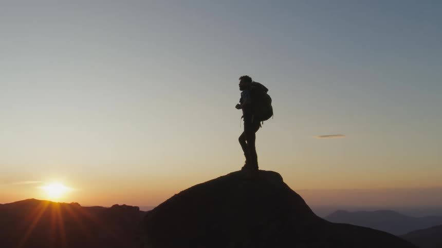 A hiker is standing on the mountain top