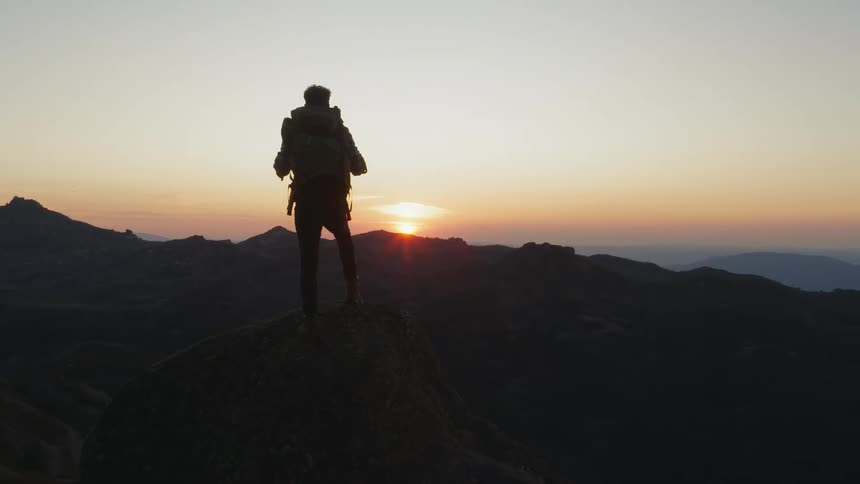 A young man is hiking outdoors in the day time