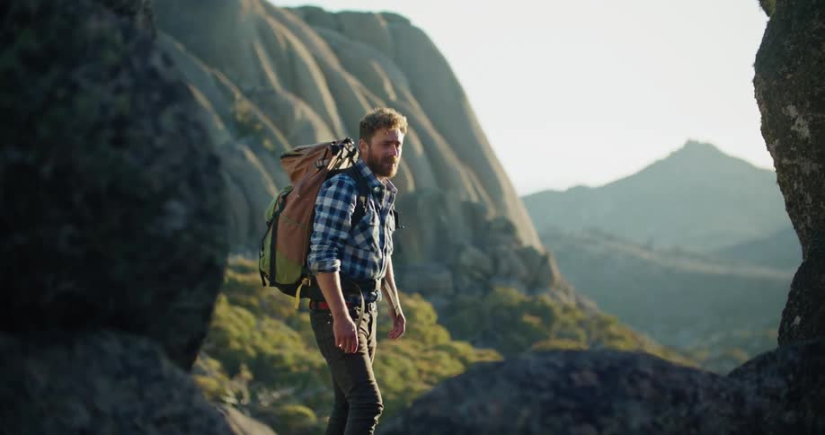 There is a young man that is hiking in the forest area