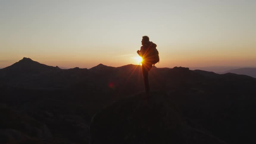 There is a man that is hiking and is wearing a backpack