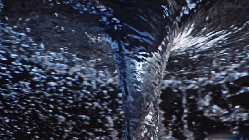 Underwater close up of a twisting water vortex