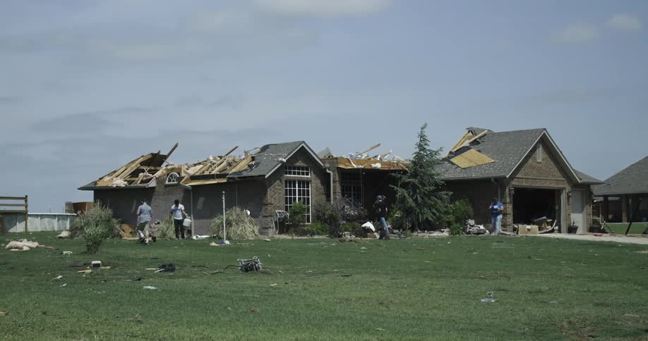 People work on a destroyed house