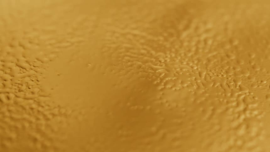Close up of abstract yellow liquid bubbling up