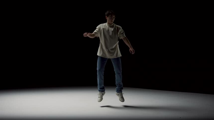 A young man reaches his arm upwards as he starts to rise and levitate