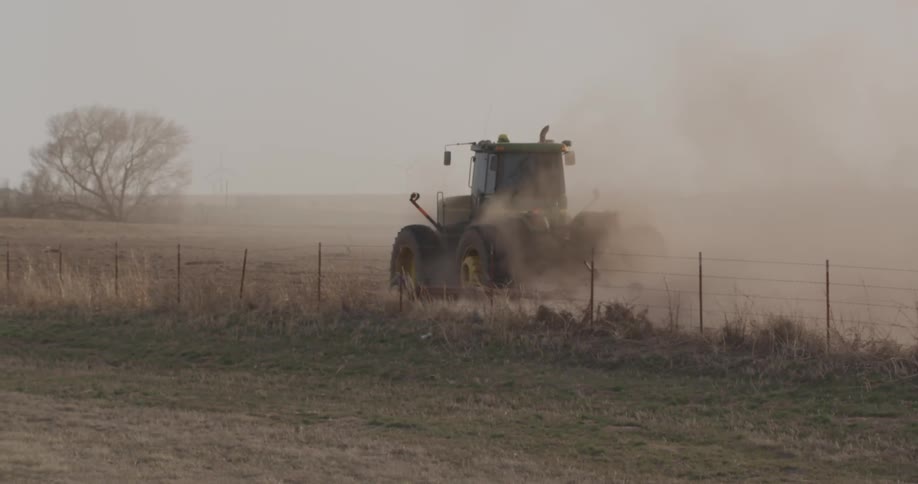 A farm vehicle works the field ahead