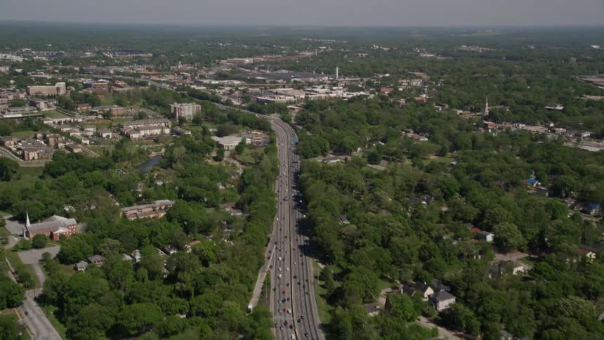 Aerial footage of a freeway in West Atlanta with light traffic tilting up to reveal surrounding residential areas