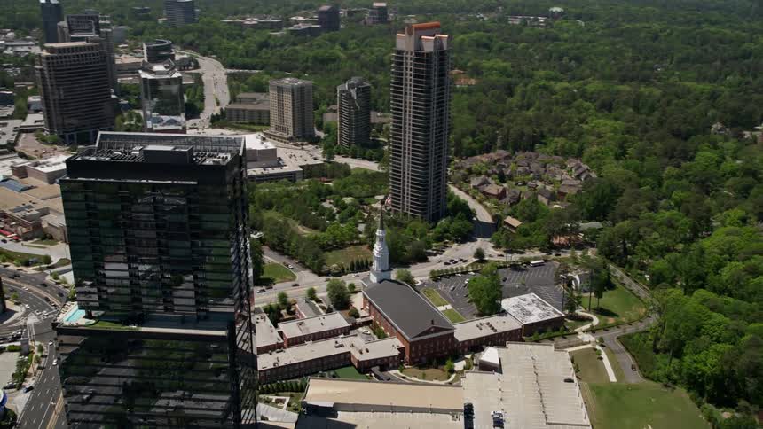 An aerial view of a bustling city reveals a Baptist church and shopping center in Buckhead Georgia