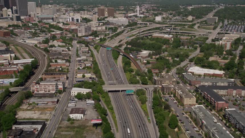 Aerial footage reveals Downtown Atlanta GA while following Ralph David Abernathy freeway during a sunny day with light traffic