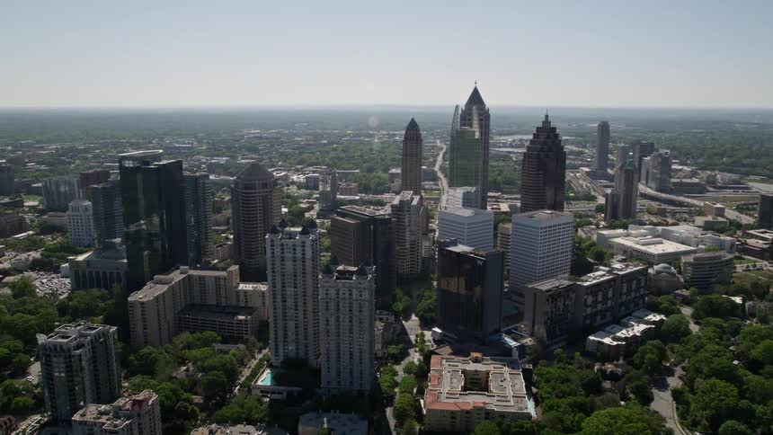 Aerial footage approaching high-rise buildings in Midtown Atlanta Georgia on a sunny day