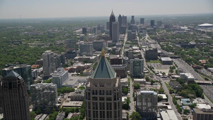 Aerial footage of Atlantas high-rise buildings during the day with a tilt up to reveal the downtown and midtown skyscrapers captured during the sunny summer season