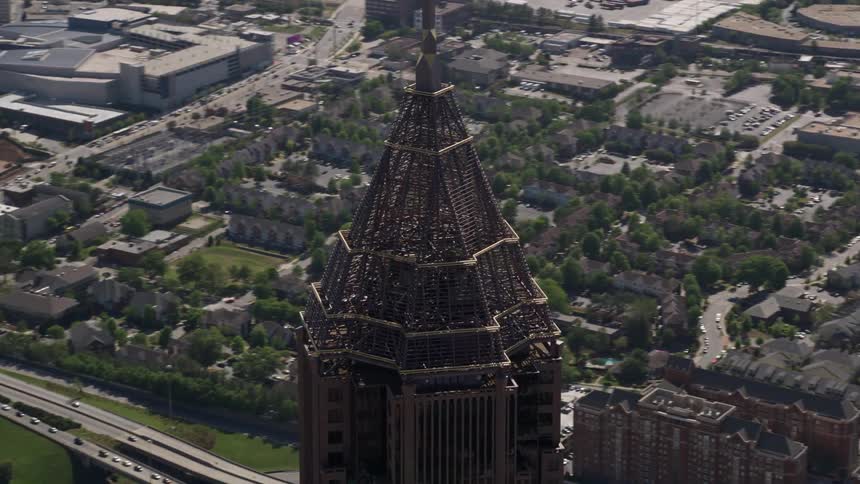 Aerial footage of Bank of America Plaza in downtown Atlanta orbiting the top of the building on a sunny day during summer