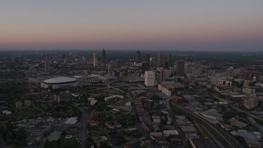 Fly above Atlantas downtown and Midtown sparkling Georgia Dome and skyscrapers at twilight