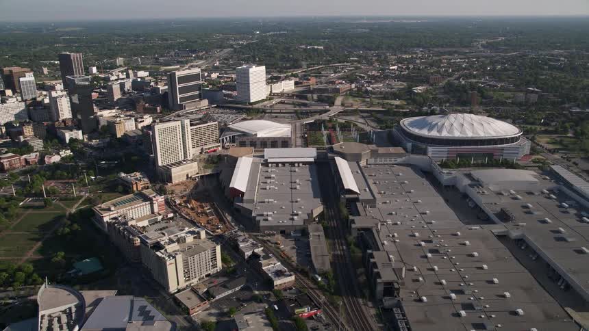 Approaching the Georgia Dome and Georgia World Congress Center seen from an orbiting aerial view in downtown Atlanta during the daytime
