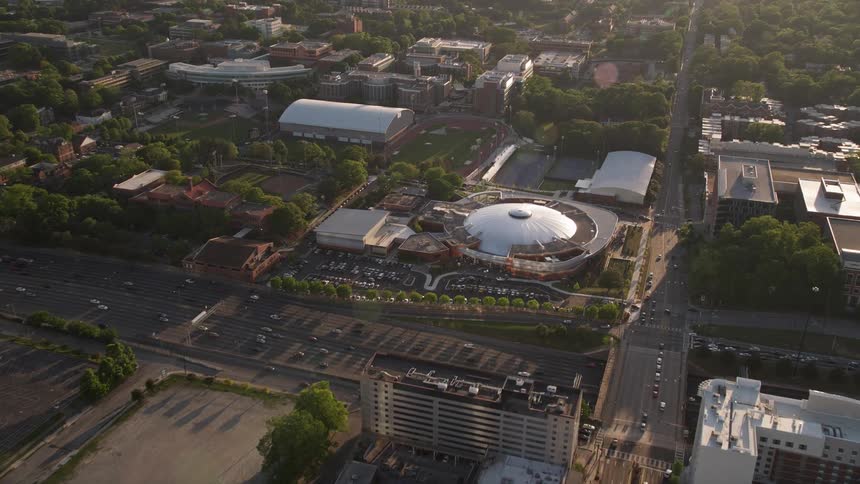Approaching the Alexander Memorial Coliseum an aerial view during sunset captures the Georgia Tech campus and the Atlanta Hawks arena