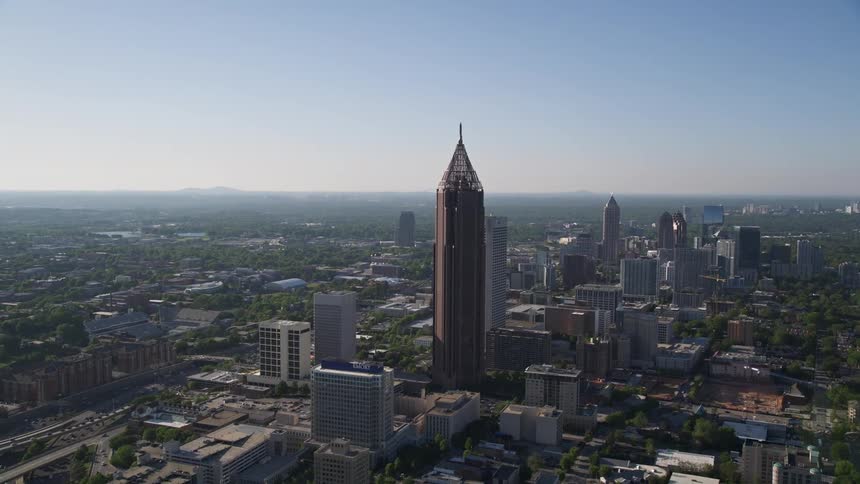 Approaching and orbiting the Bank of America Plaza in Midtown Atlanta Georgia showcasing the high-rise towers and metropolis of the city on a sunny day