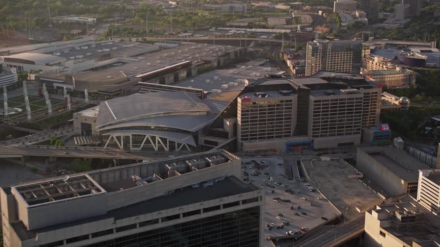 Approaching CNN Center and Philips Arena in downtown Atlanta during sunset from an aerial view