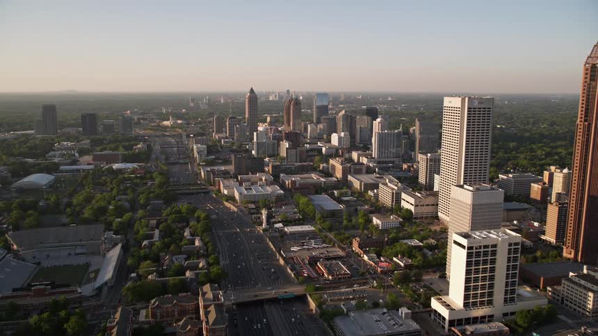 A breathtaking aerial flyby of Downtown Atlantas skyscrapers approaching Midtowns impressive buildings during sunset