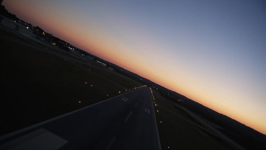 Aerial footage of a plane skews while approaching a runway at Fulton County Airport during sunset