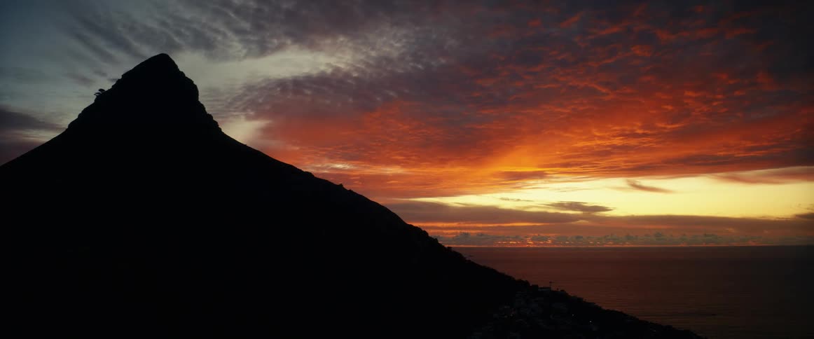 Cloud floating over a coastal mountain at sunset