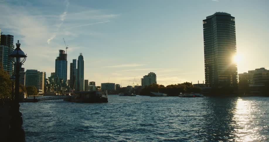Sun is low in the sky behind a building on the harbour skyline by River Thames