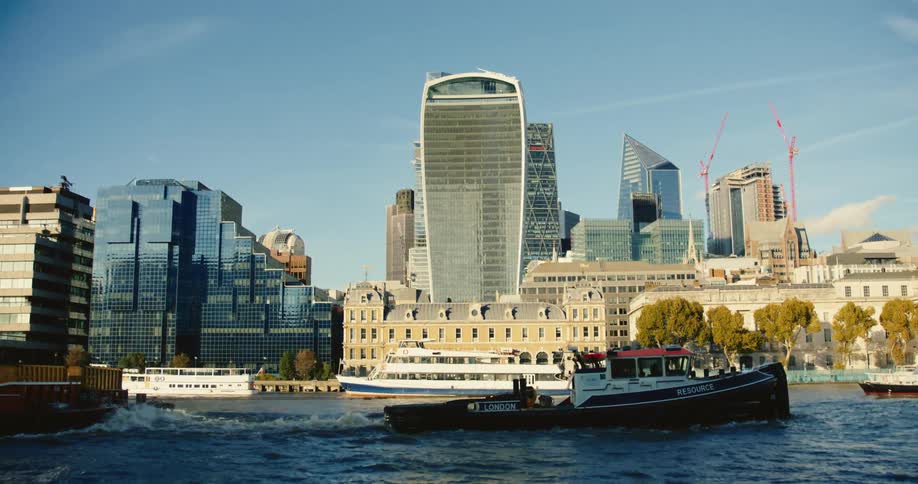 View of City of London from the River Thames as boats pass