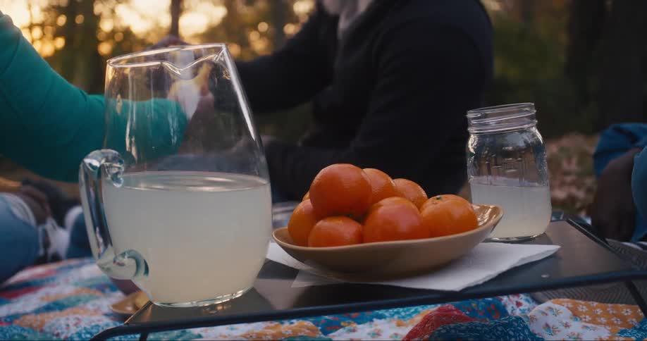 People eat oranges at a picnic