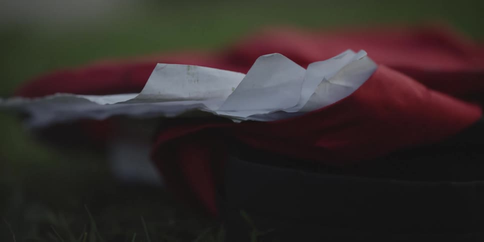 Red bag with sheets of paper on green lawn