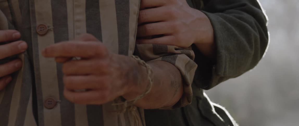 Close up of an inmate in a german concentration camp being held by the arm