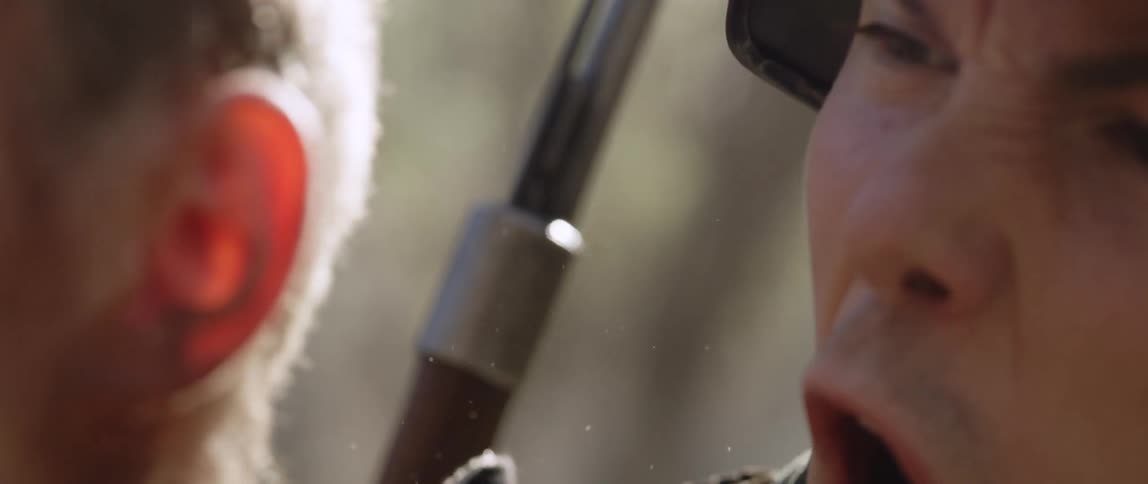 An angry soldier with a gun is yelling at another man