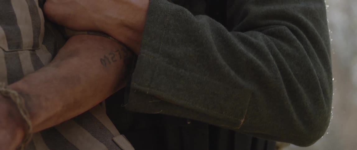 Close up of a german guard in a concentration camp violently handling a prisoner