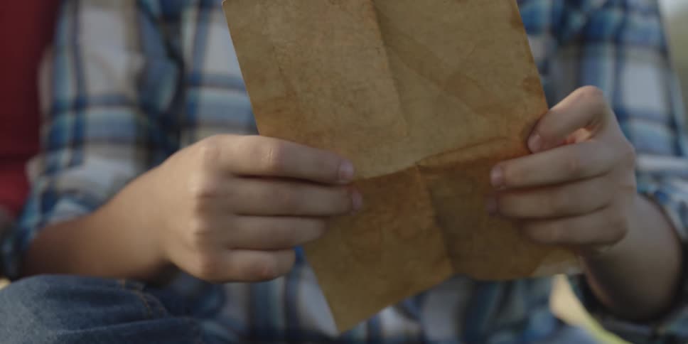 A man unfolds a piece of paper to read