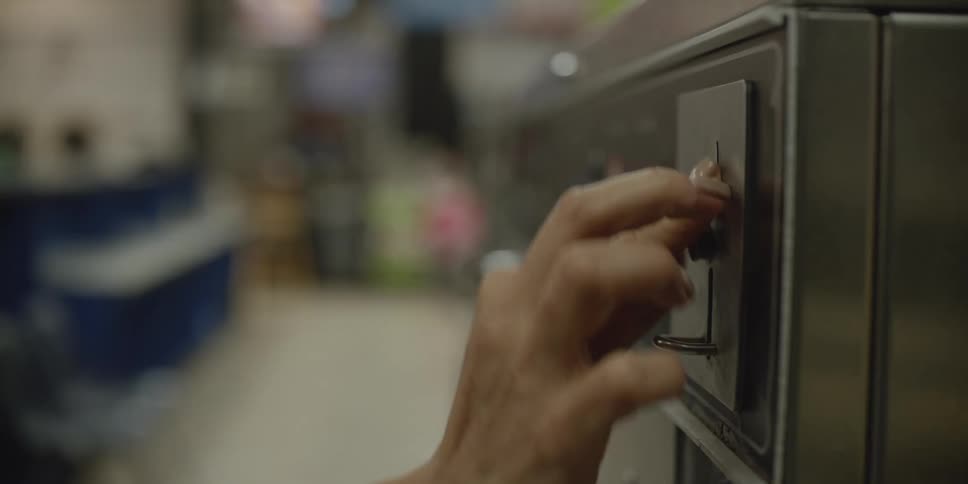 A woman putting a coin into a vending machine