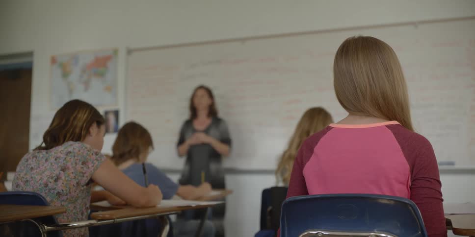 Students take notes during a classroom lesson