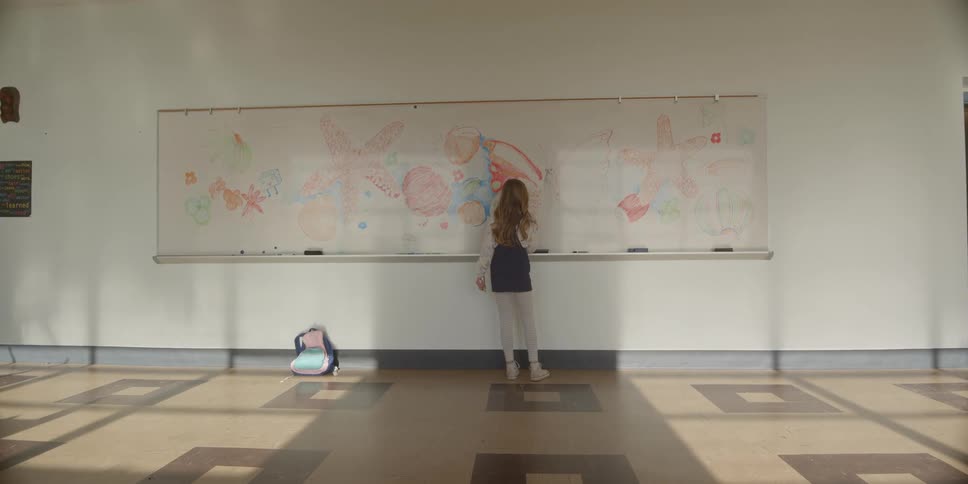 A student is drawing on the whiteboard