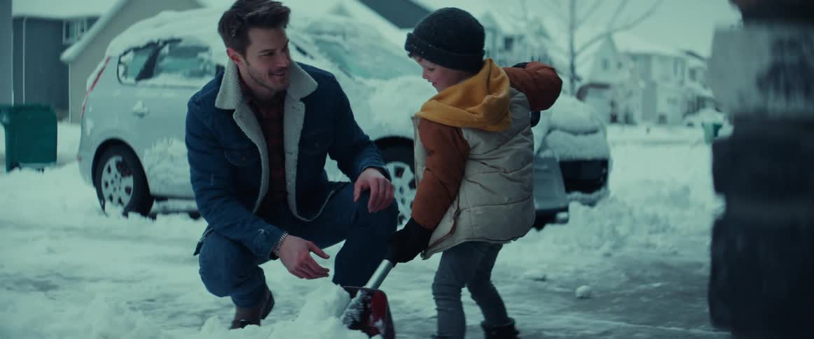 Father and son are shoveling snow outside of there driveway