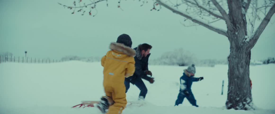 Happy family having a snowball fight on a field at winter