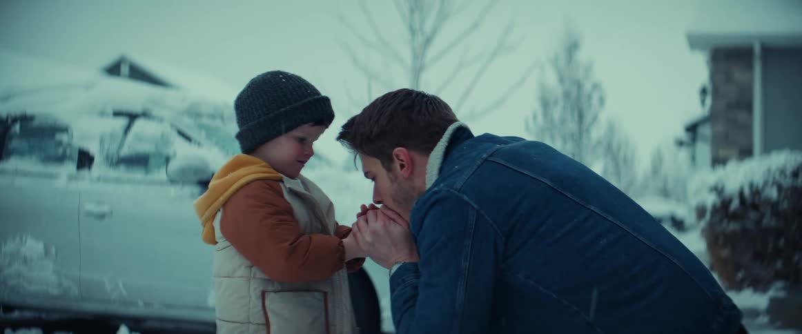 A father and his young son warming up their hands outside on a freezing winter day